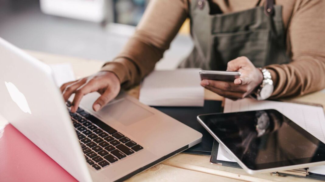 Small Business Owner Using Mobile And Laptop