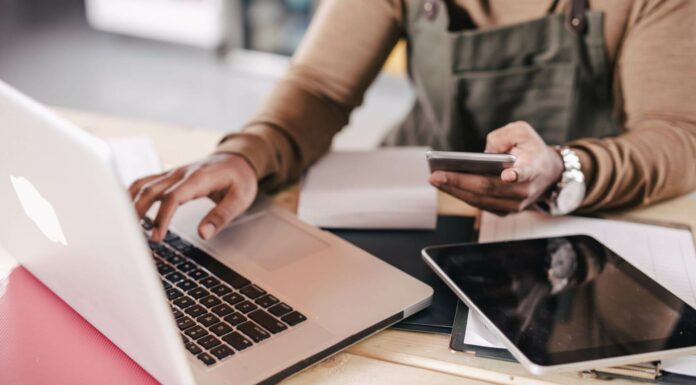 Broadband Accessibility: The Impact On Small Businesses Small Business Owner Using Mobile And Laptop