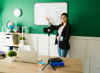 Can VoIP Revolutionise the Way We Conduct Virtual Events and Webinars? A woman in front of a whiteboard giving a virtual class streaming it through her phone.