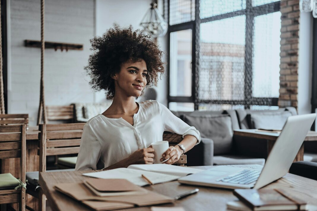 Woman working on her laptop at a desk in her home office.