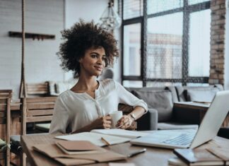 How VoIP Drives Digital Transformation in Businesses Woman working on her laptop at a desk in her home office.