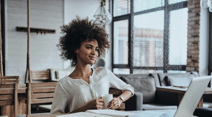 How VoIP Drives Digital Transformation in Businesses Woman working on her laptop at a desk in her home office.