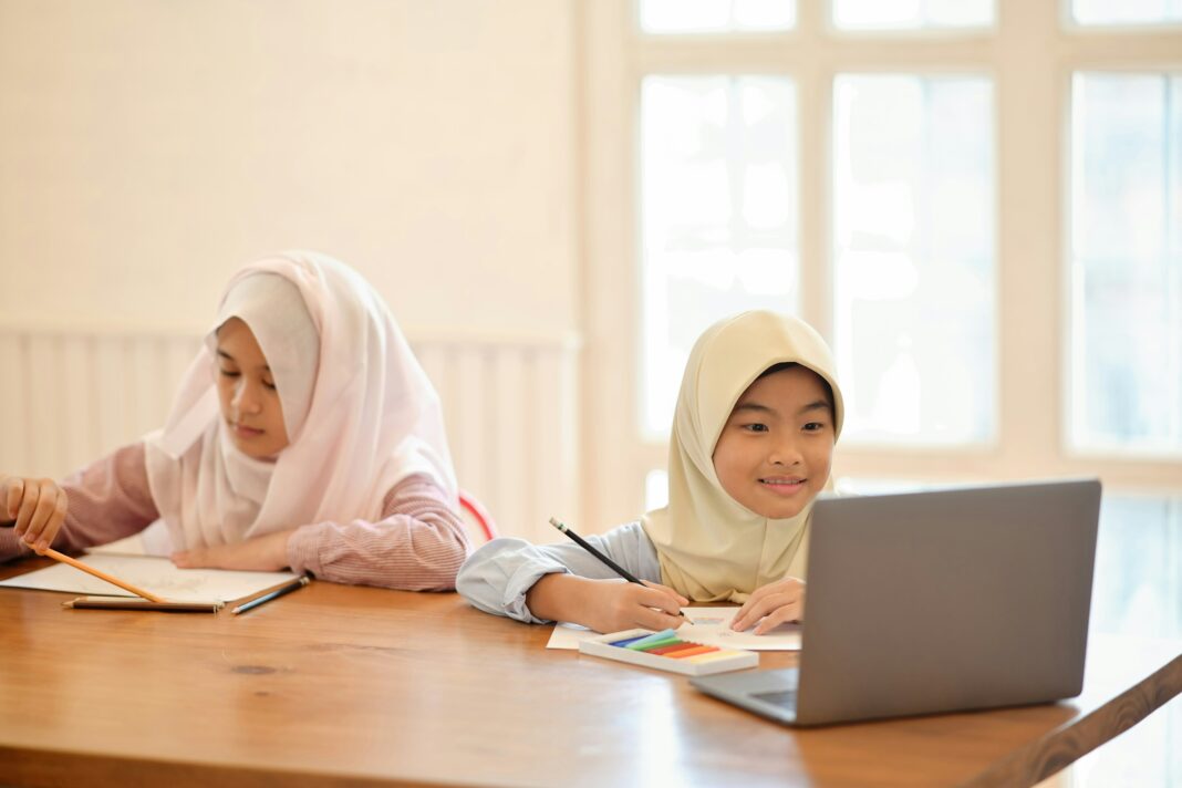 Two children sitting at a desk at home doing school work.