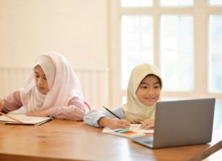 The Impact of VoIP on the Evolution of Remote Education Two children sitting at a desk at home doing school work.