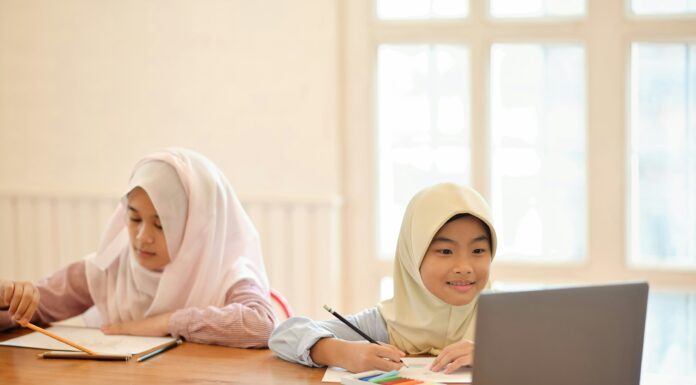 The Impact of VoIP on the Evolution of Remote Education Two children sitting at a desk at home doing school work.