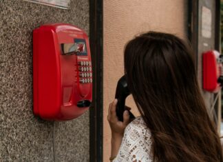 What is a Dumb Phone? A woman with brown hair talking on a public landline