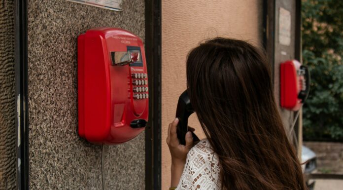 What is a Dumb Phone? A woman with brown hair talking on a public landline