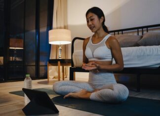 Can Broadband Internet Bridge the Urban-Rural Digital Divide? A woman sitting on the ground doing yoga while streaming a video on her tablet