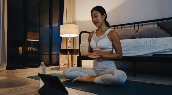 Can Broadband Internet Bridge the Urban-Rural Digital Divide? A woman sitting on the ground doing yoga while streaming a video on her tablet
