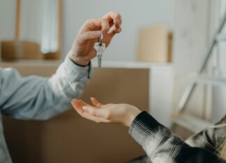 How Does Broadband Availability Influence Real Estate Investment? Photo of a person handing the keys of a new house to someone else