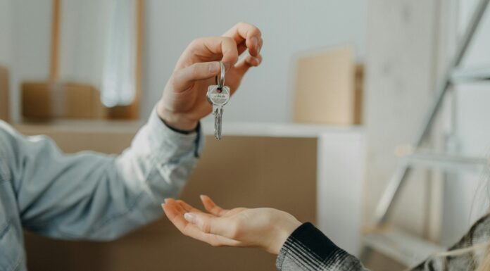 How Does Broadband Availability Influence Real Estate Investment? Photo of a person handing the keys of a new house to someone else