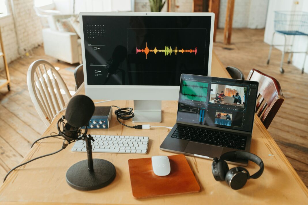 Photo of a screen, microphone, and laptop busy recording video and audio