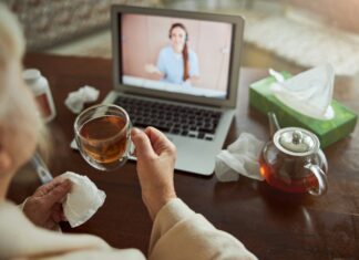 What Are the Benefits of Broadband for Telemedicine Applications? | CommsLink Someone consulting a dr online from their home while drinking tea