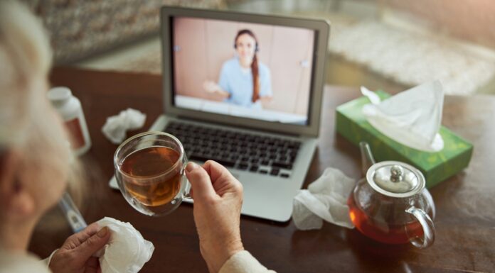 What Are the Benefits of Broadband for Telemedicine Applications? | CommsLink Someone consulting a dr online from their home while drinking tea