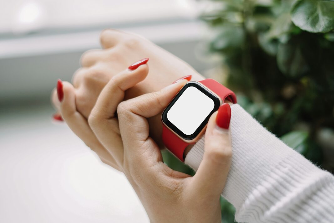 What Are the Privacy Concerns Surrounding Connected Devices? A woman wearing a smart watch around her wrist with a red strap