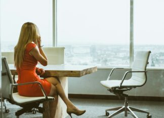 Common VoIP Mistakes to Avoid A woman sitting on a chair at her desk talking on the phone while looking out a window