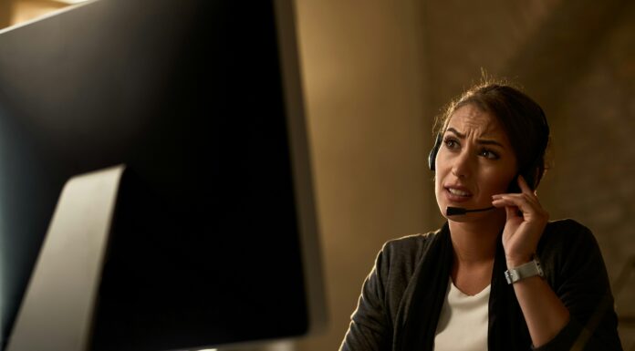 Do I Need a Special Phone for VoIP? Photo of a woman sitting in front of a computer screen talking on a headset