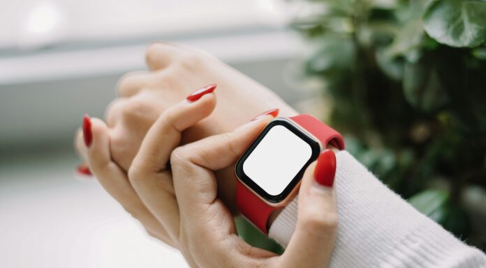 How Does Broadband Support the Internet of Things? A woman with red nails checking on her smart watch with a red strap