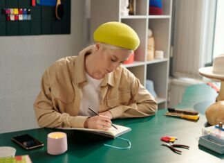 The Best VoIP Phones for Small Businesses Woman sitting at her desk drawing on a piece of paper