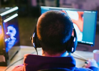 Top 10 Tips for Maximising Your Home Broadband Speed Man sitting at his desk playing games with his headphones on