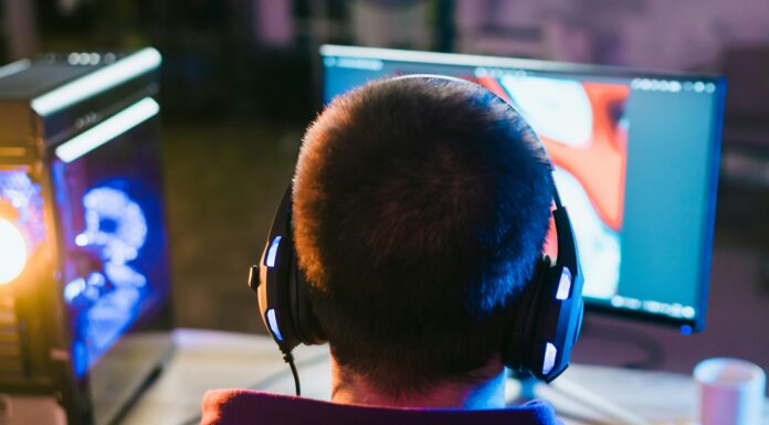 Top 10 Tips for Maximising Your Home Broadband Speed Man sitting at his desk playing games with his headphones on