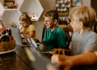 What Are the Economic Benefits of Broadband Investment? Three children sitting at a table with their laptops doing work