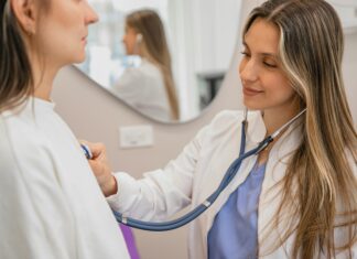 What Are the Key Benefits of Connectivity in the Healthcare Sector? A dr. using her stethoscope to listen to a patient's heart