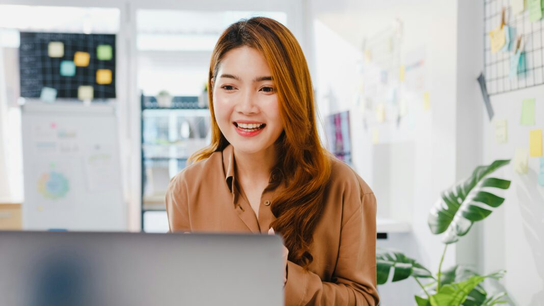 Woman sitting at her desk talking on her computer