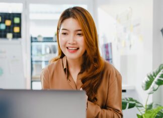 What is the Ideal Bandwidth for VoIP? Woman sitting at her desk talking on her computer