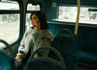 10 Advantages of VoIP Over Traditional Landlines A woman wearing a jacket sitting on a bus while talking on the phone