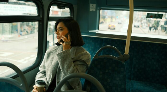 10 Advantages of VoIP Over Traditional Landlines A woman wearing a jacket sitting on a bus while talking on the phone