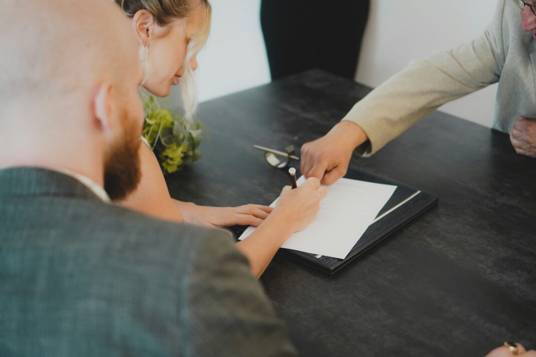 5 Questions to Ask Before Signing a Business Broadband Contract A woman sitting at a table signing a contract