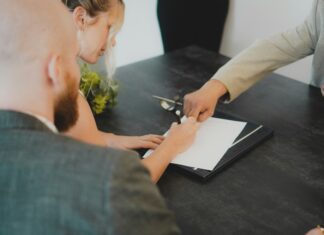 5 Questions to Ask Before Signing a Business Broadband Contract A woman sitting at a table signing a contract
