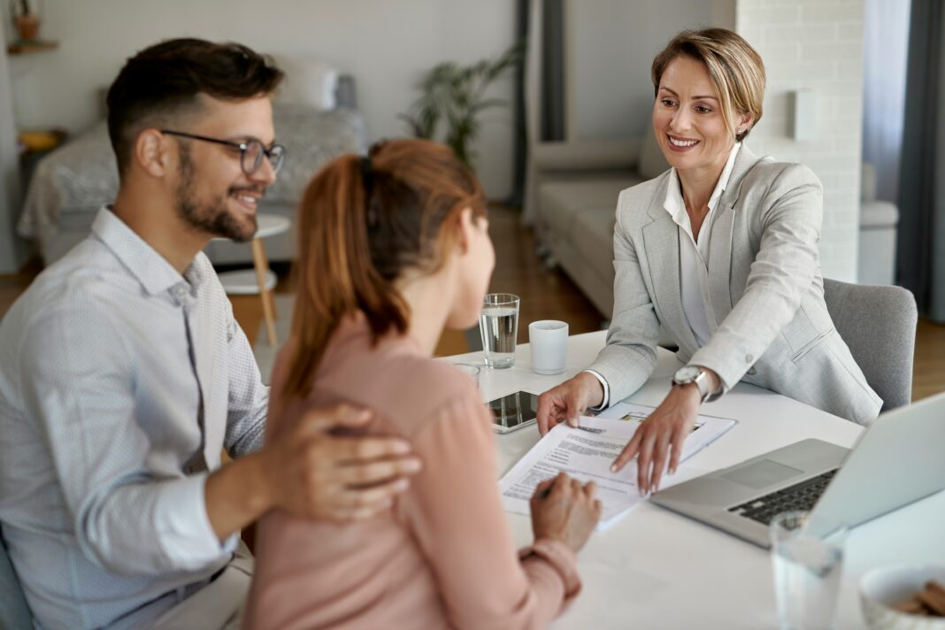8 Reasons Real Estate Agents Should Use VoIP A couple signing a contract while sitting across from a real estate agent