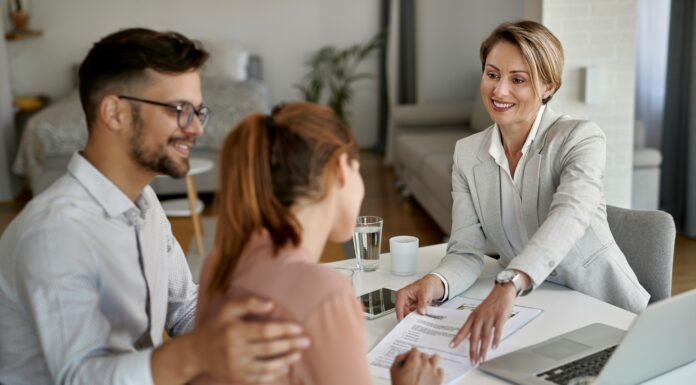 8 Reasons Real Estate Agents Should Use VoIP A couple signing a contract while sitting across from a real estate agent