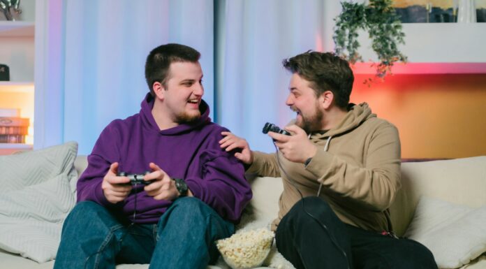 Can I Use VoIP With Starlink? Two men sitting on a couch with gaming remotes laughing