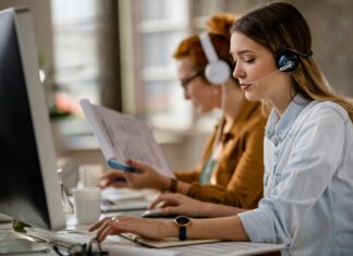 Can VoIP Handle Large Call Volumes? A woman sitting at her desk in front of a computer screen with a headset on