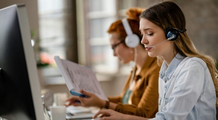 Can VoIP Handle Large Call Volumes? A woman sitting at her desk in front of a computer screen with a headset on