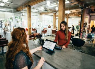 Can VoIP Help Small Businesses Expand Globally? A woman standing behind the register helping a customer