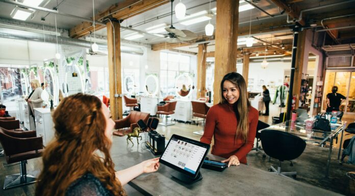 Can VoIP Help Small Businesses Expand Globally? A woman standing behind the register helping a customer