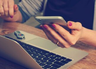 Is Mobile Broadband as Good as Fibre? A woman sitting in front of her laptop while typing on her phone