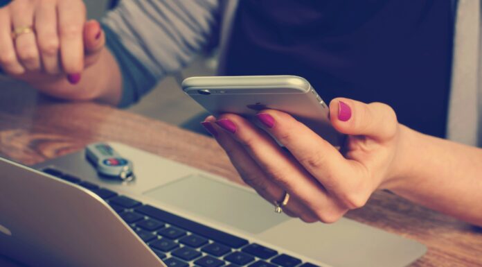 Is Mobile Broadband as Good as Fibre? A woman sitting in front of her laptop while typing on her phone
