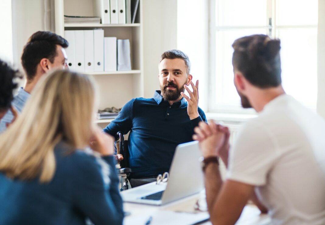 A group of people sitting in an office talking