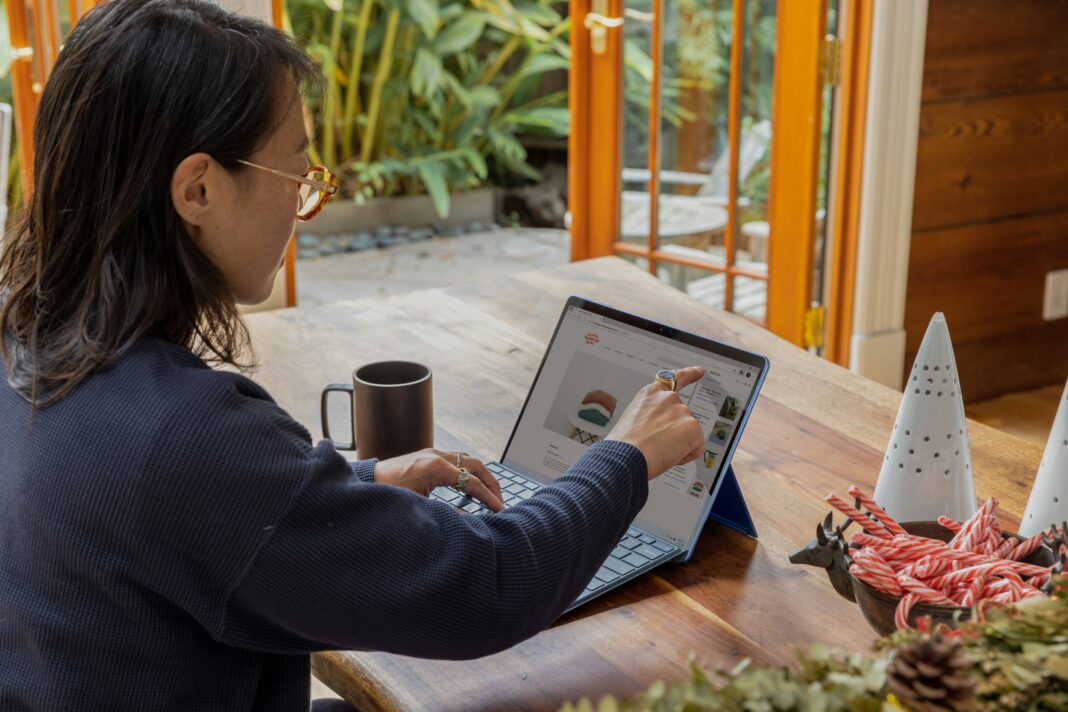 A woman sitting at her desk with coffee working on her laptop