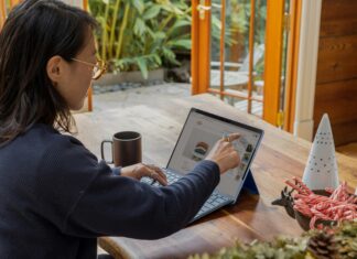 Top 5 Tips for Choosing the Right VoIP Provider A woman sitting at her desk with coffee working on her laptop