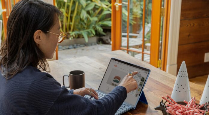 Top 5 Tips for Choosing the Right VoIP Provider A woman sitting at her desk with coffee working on her laptop