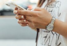 What Are the Main Benefits of Using a Dumb Phone? A woman wearing a silver watching typing on a white phone