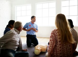What Role Does Broadband Connectivity Play in Disaster Preparedness? A group of people sitting in a room in front of a cpr instructor