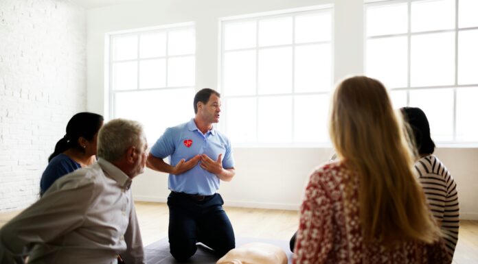 What Role Does Broadband Connectivity Play in Disaster Preparedness? A group of people sitting in a room in front of a cpr instructor