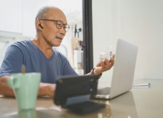 Why Are VoIP Adapters Useful? A man sitting at his laptop with earphones and a mug of coffee